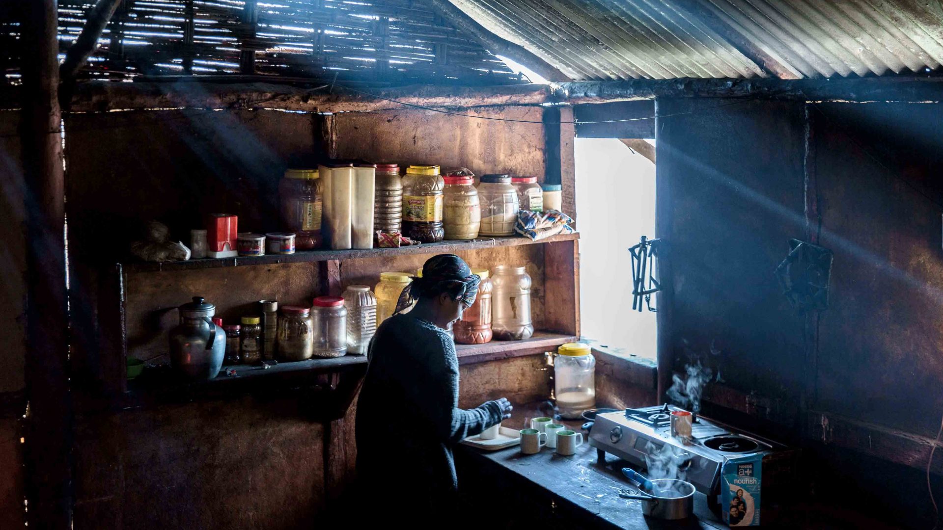 A woman makes tea in a Monpa kitchen in Arunachal Pradesh, India.